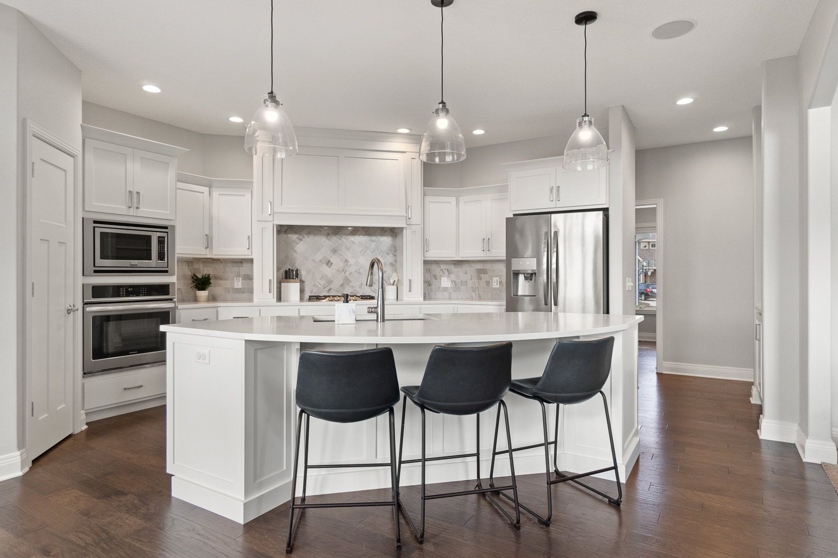 White kitchen with large island and stainless appliances