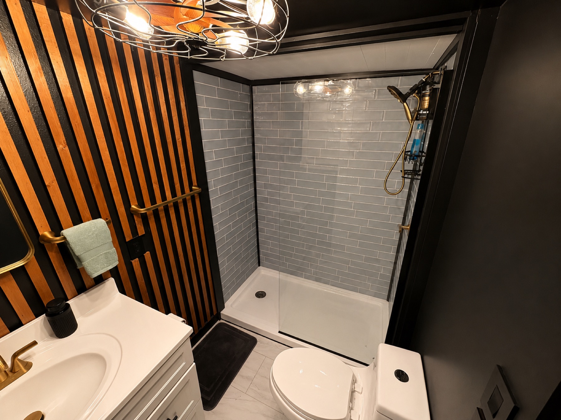 Modern bathroom with a walk-in subway-tile shower and brass fixtures