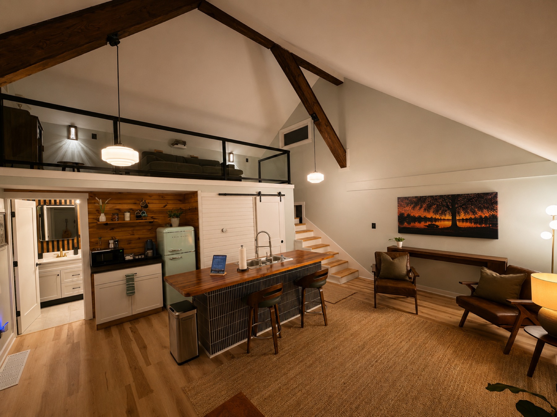 Open-plan living area with vaulted ceiling, wood island, and the sleeping loft above