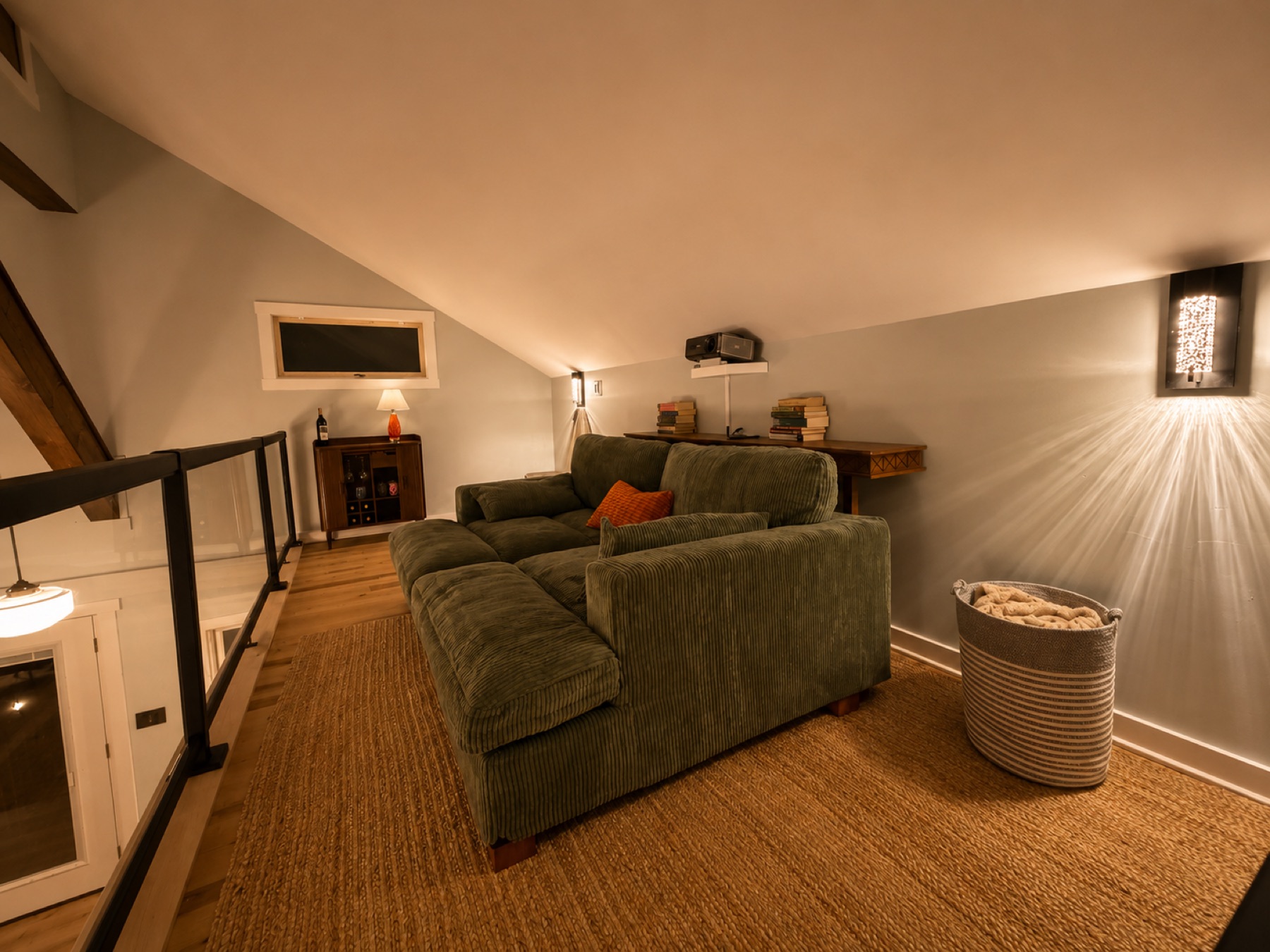 Green corduroy sectional in the loft lounge under a sloped ceiling