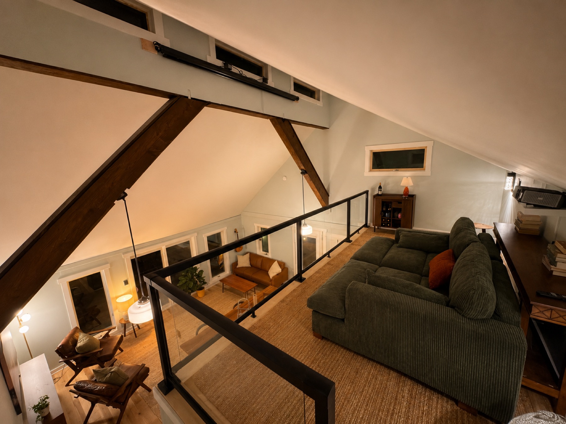 Looking down from the finished loft over the living room and beams