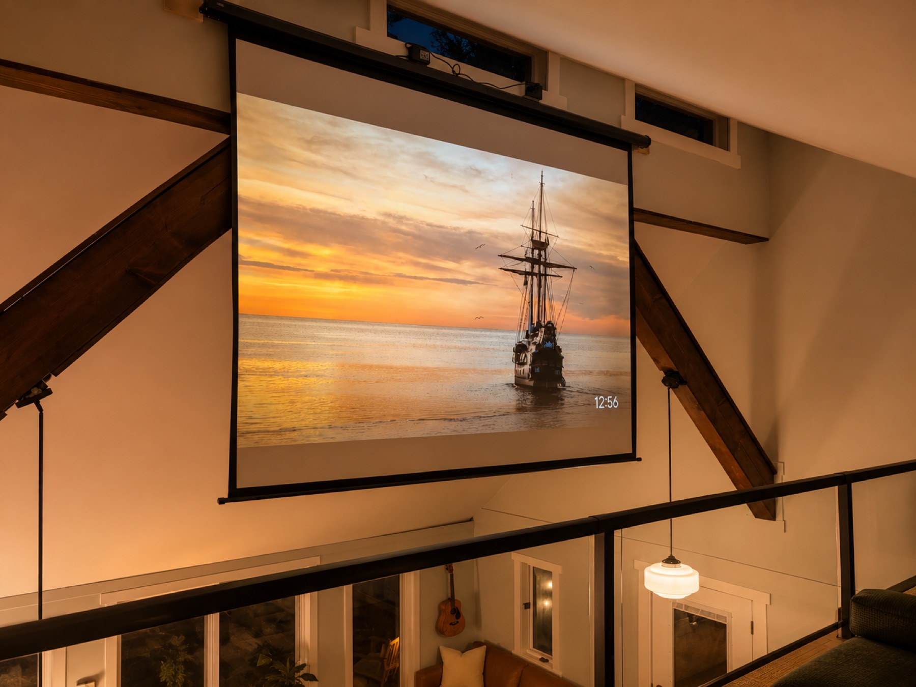 Drop-down projector screen playing a film beneath the loft rafters