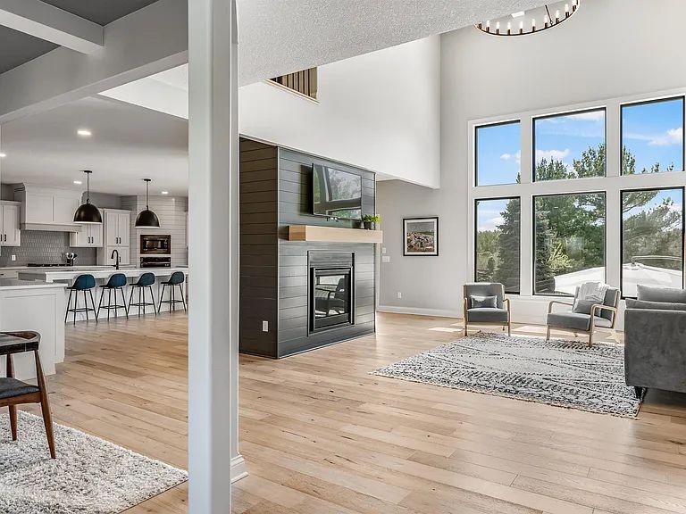 Great room with two-storey windows, fireplace and open kitchen