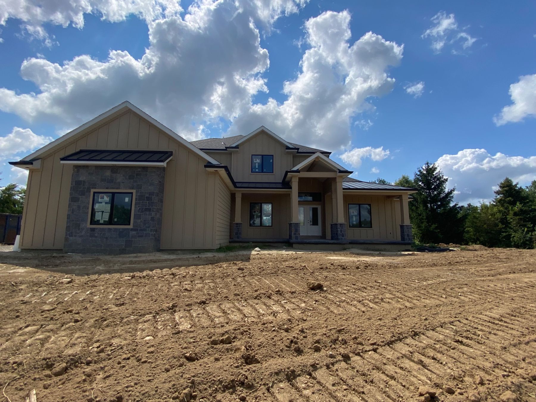 The house framed and sided, lot still bare dirt
